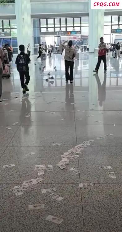 广州一高铁站女子边走边撒大量现金 行为引发众人疑惑